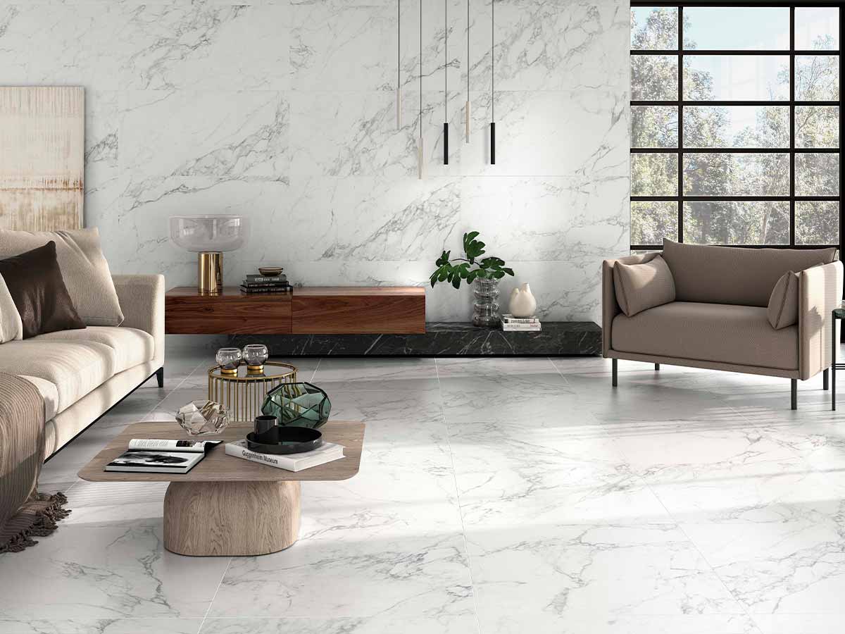 Ambiente de salón luminoso con suelo porcelánico Sabine de imitación mármol blanco con vetas
