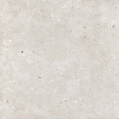 Baldosa de imitación piedra Glamstone White con textura granulada en tonos blancos y grises, salpicada de pequeñas motas de colores variados