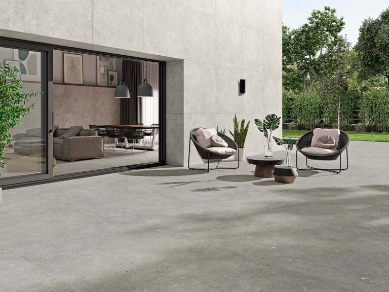 Fachada de una casa moderna revestida con porcelánico Glamstone White, que aporta una textura de efecto piedra en color claro y contrasta con el suelo de la terraza.