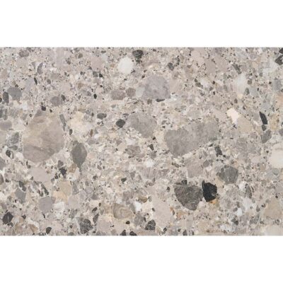 Primer plano de la textura de un azulejo efecto piedra, modelo Inlay, con fragmentos en tonos naturales grises y beige.