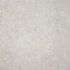 Primer plano de un azulejo porcelánico Caliope Pearl, mostrando su textura de efecto piedra caliza en un tono gris perla claro con incrustaciones fósiles.