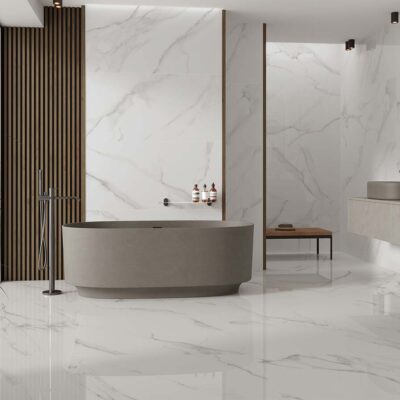 Ambiente de un baño de lujo con el suelo y las paredes completamente revestidos con el azulejo pulido Lumiere White, creando un espacio continuo y luminoso de imitación de mármol blanco.