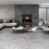 Salón moderno con suelo y pared de chimenea revestidos con azulejo porcelánico Malek Black, efecto piedra oscura con vetas blancas.