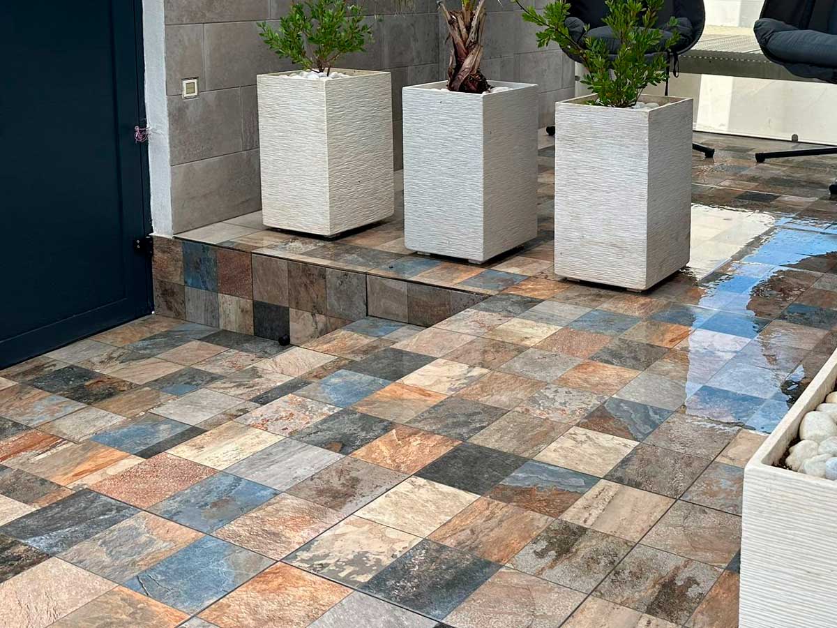 Patio exterior con baldosas cerámicas de diferentes colores y diseños