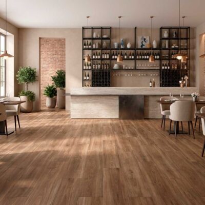 El suelo porcelánico nogal Kimberley viste un restaurante con mesas y una barra.