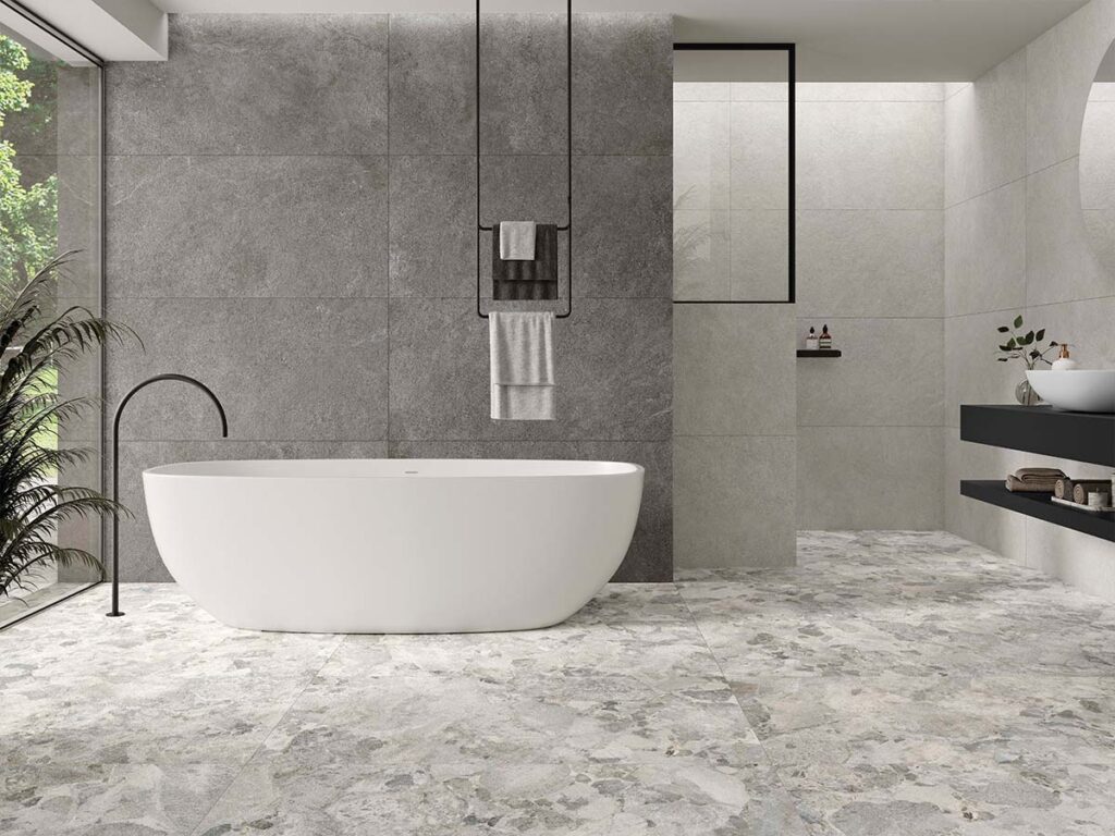 Suelo de un baño de diseño pavimentado con baldosas antideslizantes Larocca Grey, mostrando su realista textura de efecto piedra en color gris.