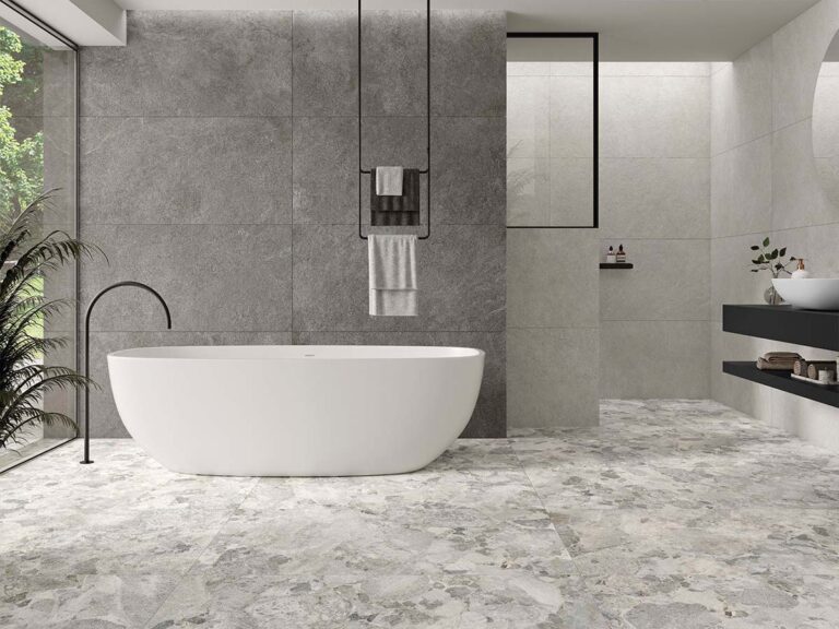 Suelo de un baño de diseño pavimentado con baldosas antideslizantes Larocca Grey, mostrando su realista textura de efecto piedra en color gris.