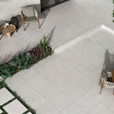 Terraza exterior pavimentada con suelo porcelánico antideslizante Caliope Pearl, creando un amplio y moderno espacio al aire libre.