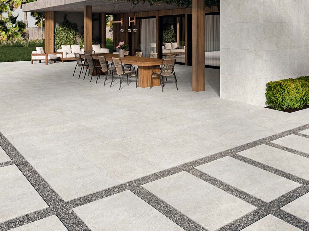 Terraza exterior con suelo porcelánico antideslizante modelo Flax Pearl, que recrea el efecto cemento en un luminoso color perla.