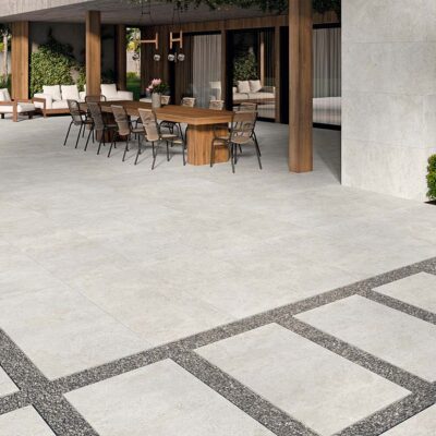 Terraza exterior con suelo porcelánico antideslizante modelo Flax Pearl, que recrea el efecto cemento en un luminoso color perla.