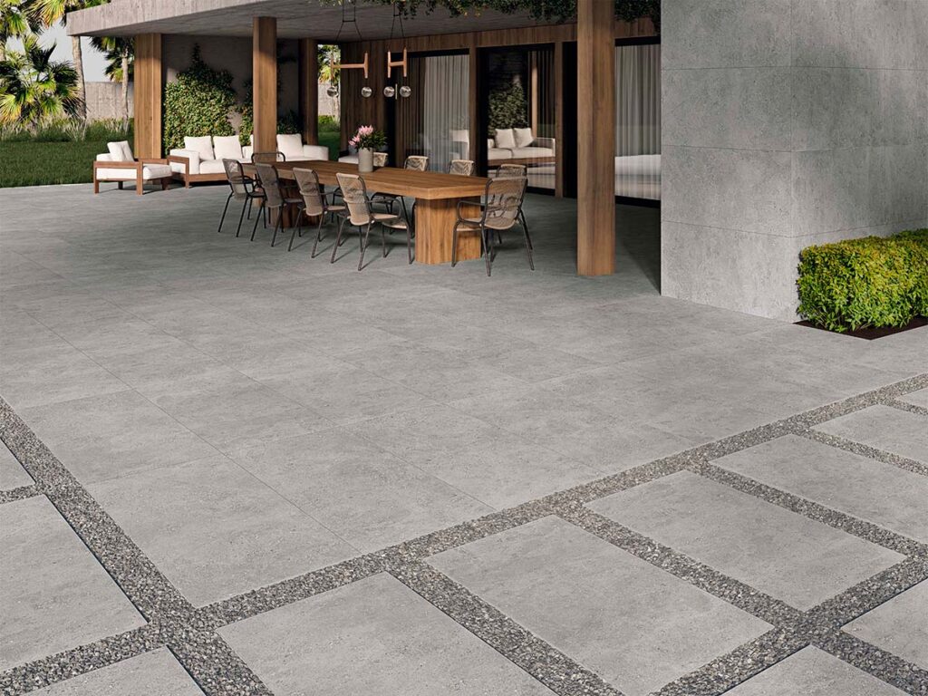 Suelo de terraza exterior pavimentado con porcelánico antideslizante modelo Flax Grey, de color gris y aspecto cementoso.