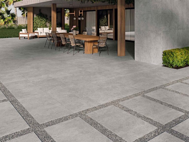 Suelo de terraza exterior pavimentado con porcelánico antideslizante modelo Flax Grey, de color gris y aspecto cementoso.
