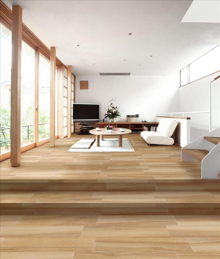 Salón moderno con suelo porcelánico imitación madera Alpina Miel Ambiente y grandes ventanales.
