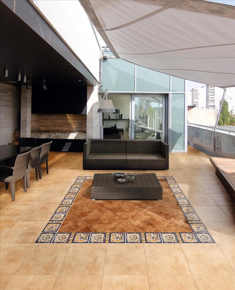 Suelo de terra gres en terraza moderna con zona central de baldosas decorativas.