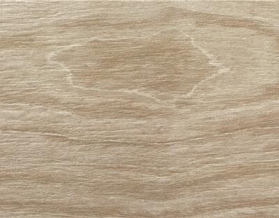 Primer plano de una pieza de porcelánico imitación madera en tono miel.