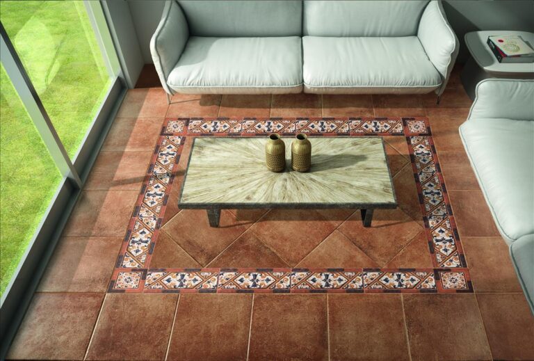 Suelo Olba Cotto Ambiente de terracota en un salón. Una cenefa decorativa enmarca la mesa de centro.