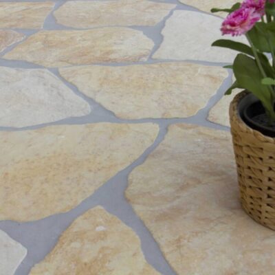Pavimento de piedra natural en tonos beige y marrón, ideal para exteriores.