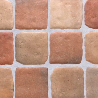 detalle de pavimento porcelánico benisa cotto con piezas cuadradas en tonos terracota y beige efecto barro artesanal