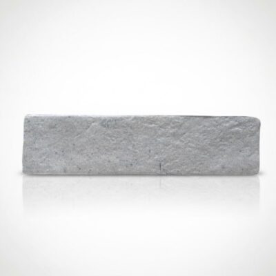 Azulejo gris con textura de piedra tosca sobre fondo claro. Consulta piedra tosca precio.