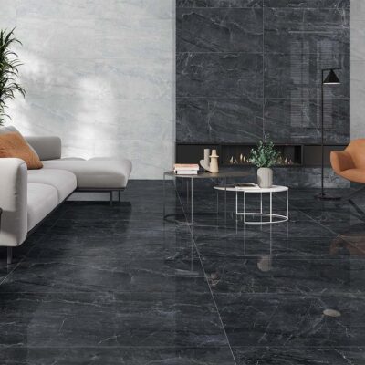 Paredes de un salón de lujo revestidas con el azulejo porcelánico Sublime White, que aporta un fondo luminoso de efecto mármol y contrasta con el suelo y la chimenea de mármol negro pulido.