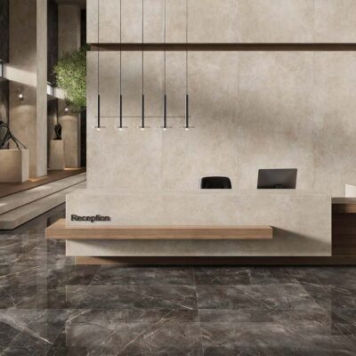 Ambiente de una recepción de lujo con las paredes y el mostrador revestidos con la baldosa Feroe Greige de imitación piedra, creando un fondo neutro y elegante.