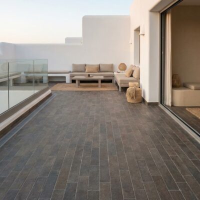 Terraza exterior con suelo porcelánico antideslizante tosca visón y mobiliario beige.