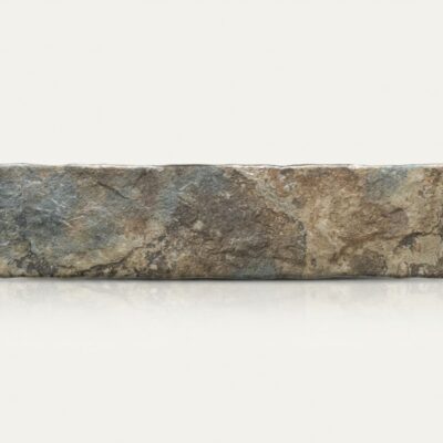 Baldosa porcelánica rústica con efecto piedra en tonos marrones y grises.