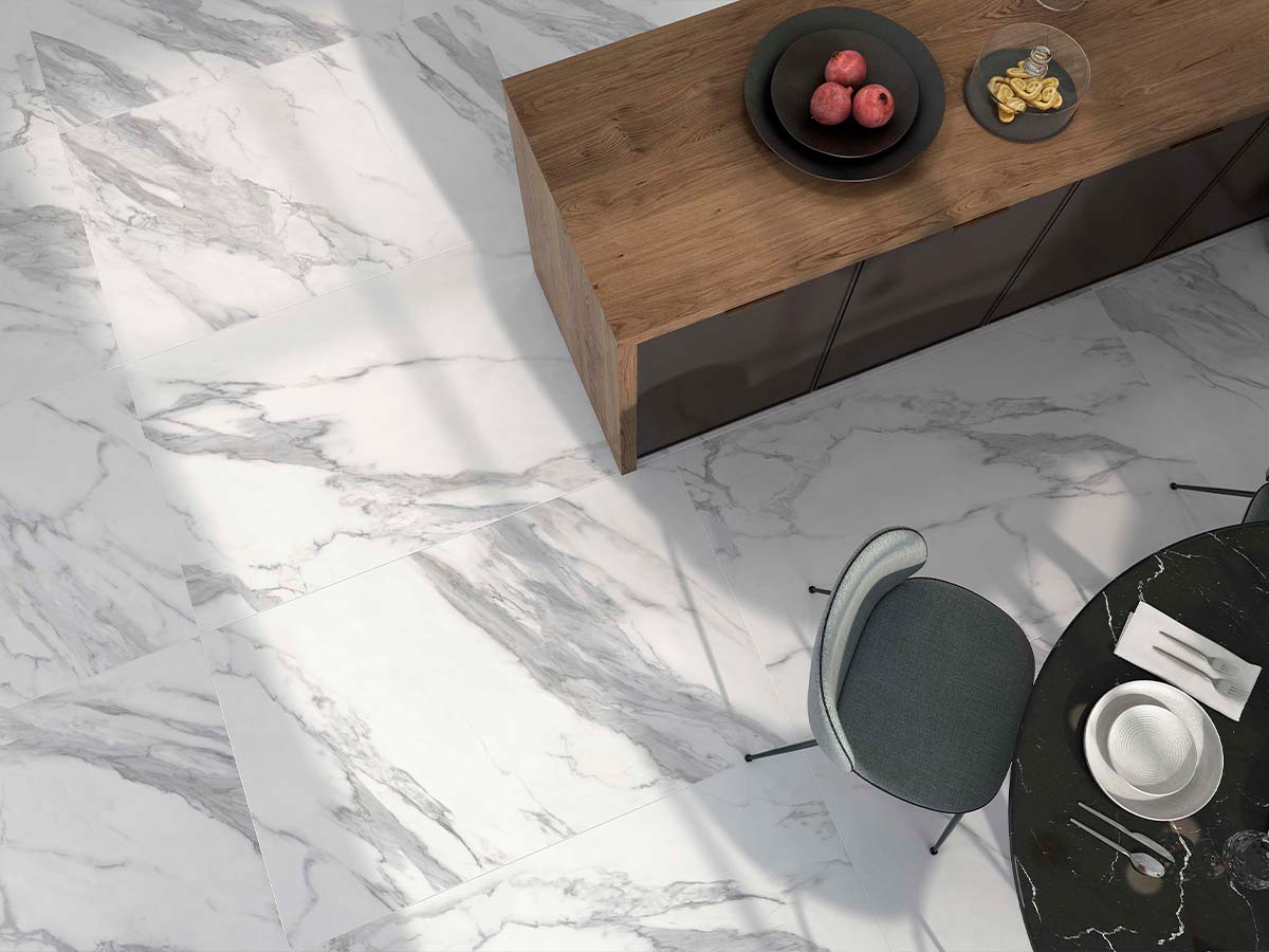 Ambiente de baño luminoso con suelo y pared de porcelánico Even imitación mármol blanco veteado