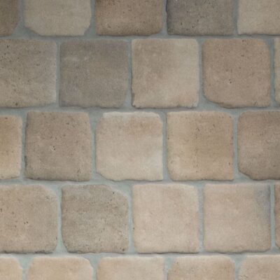 azulejo cerámico cuadrado de imitación barro con una superficie de textura rústica y bordes irregulares en tonos tierra y ocre