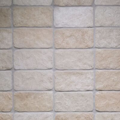 azulejo imitación piedra country beige de formato rectangular con bordes irregulares y superficie de textura mineral rugosa en tonos tierra, arena y crema