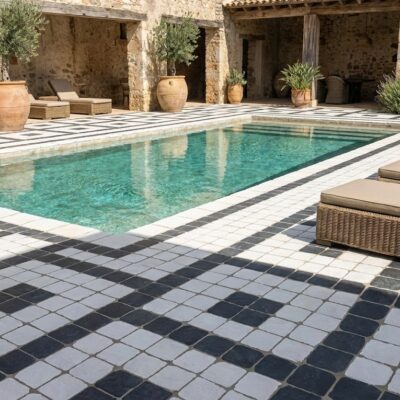 Piscina exterior con suelo porcelánico de diseño ajedrezado blanco y negro, rodeada de tumbonas.
