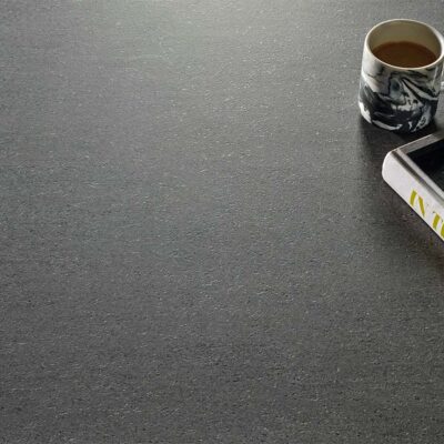 Suelo y pared de un baño de diseño revestidos con porcelánico para interior Dama Graphite, creando un look total en gris oscuro.