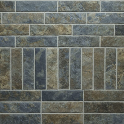 pared revestida con azulejos porcelánicos rectangulares que imitan piedra natural en tonos grises y ocres con texturas minerales