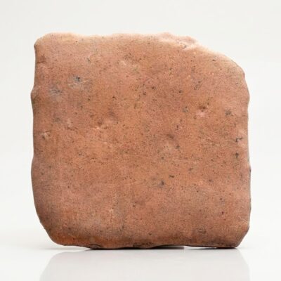 Rachola cerámica efecto barro cotto de tono rojizo con superficie rústica y bordes irregulares.