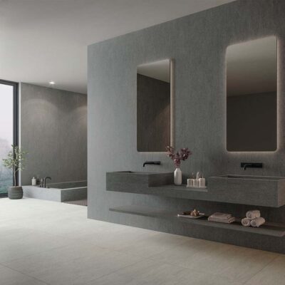 Fachada exterior revestida con porcelánico Dama Graphite, mostrando su robusta textura de efecto piedra en un elegante color grafito oscuro.