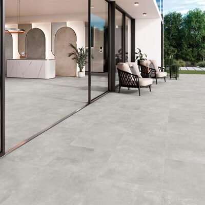 suelo porcelánico antideslizante exterior indeed silver en terraza moderna con butacas de diseño y vistas al jardín