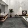 Salón con suelo porcelánico modelo Feroe Tobacco, que imita la textura del cemento en un cálido tono marrón.