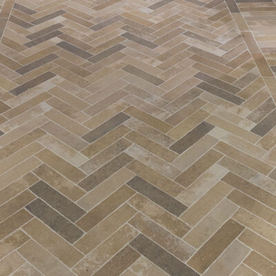 suelo porcelánico exterior imitación piedra tono beige con azulejos en espiga y textura antideslizante