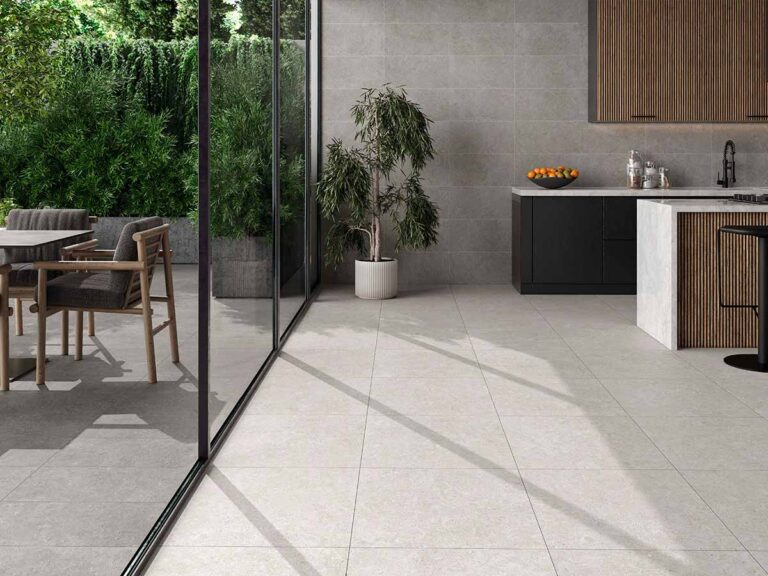 Suelo porcelánico imitación cemento, modelo Ulisse, en color perla, instalado en una cocina moderna con acceso a terraza