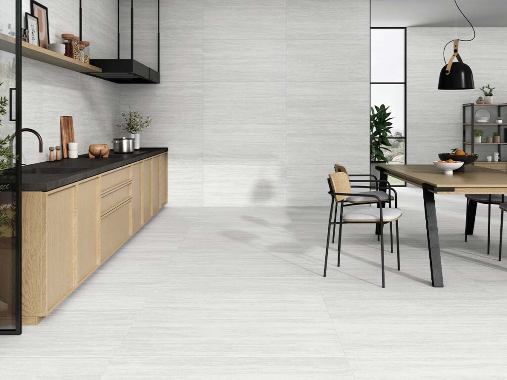 Ambiente de una cocina moderna con el suelo y las paredes revestidos con el porcelánico Fortune Pearl, mostrando su textura de imitación de mármol con veta horizontal en tono perla.
