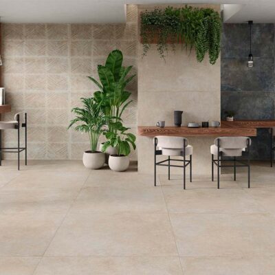 Ambiente de cafetería moderna con suelo porcelánico Feroe Greige de imitación piedra, que unifica el espacio y combina con paredes de distintos acabados.
