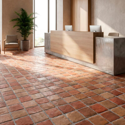 Suelo rústico interior Benisa Cotto en una recepción luminosa con mostrador y asientos.