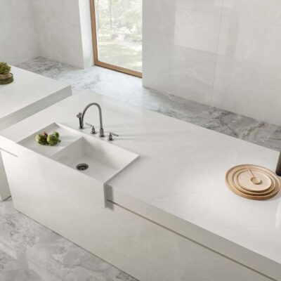 Suelo de baño con bañera exenta y pavimento porcelánico Scarlet Soft White imitación mármol.