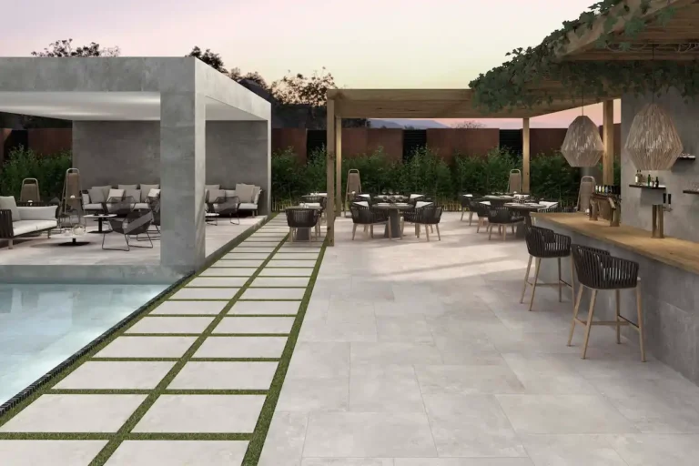 suelo porcelánico exterior efecto cemento gris en terraza con piscina, zona chill out y bar al aire libre con mobiliario moderno