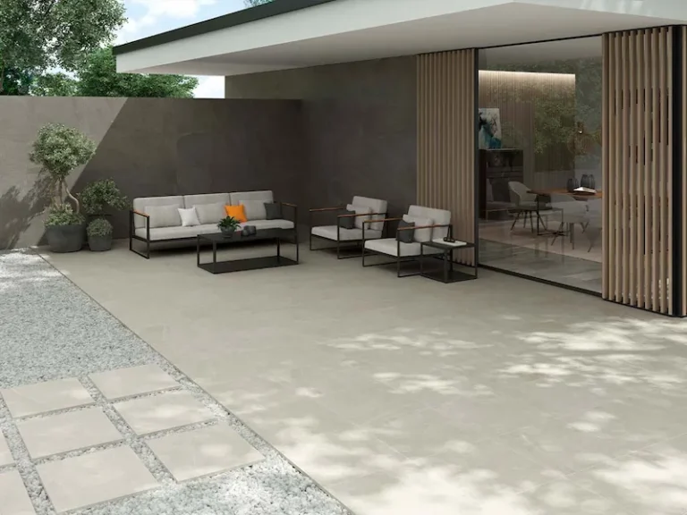 suelo porcelánico antideslizante color marfil en terraza exterior moderna con zona de estar y mobiliario de jardín
