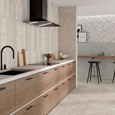 Cocina moderna con suelo porcelánico imitación piedra y revestimiento cerámico efecto mosaico en tonos beige y crema.