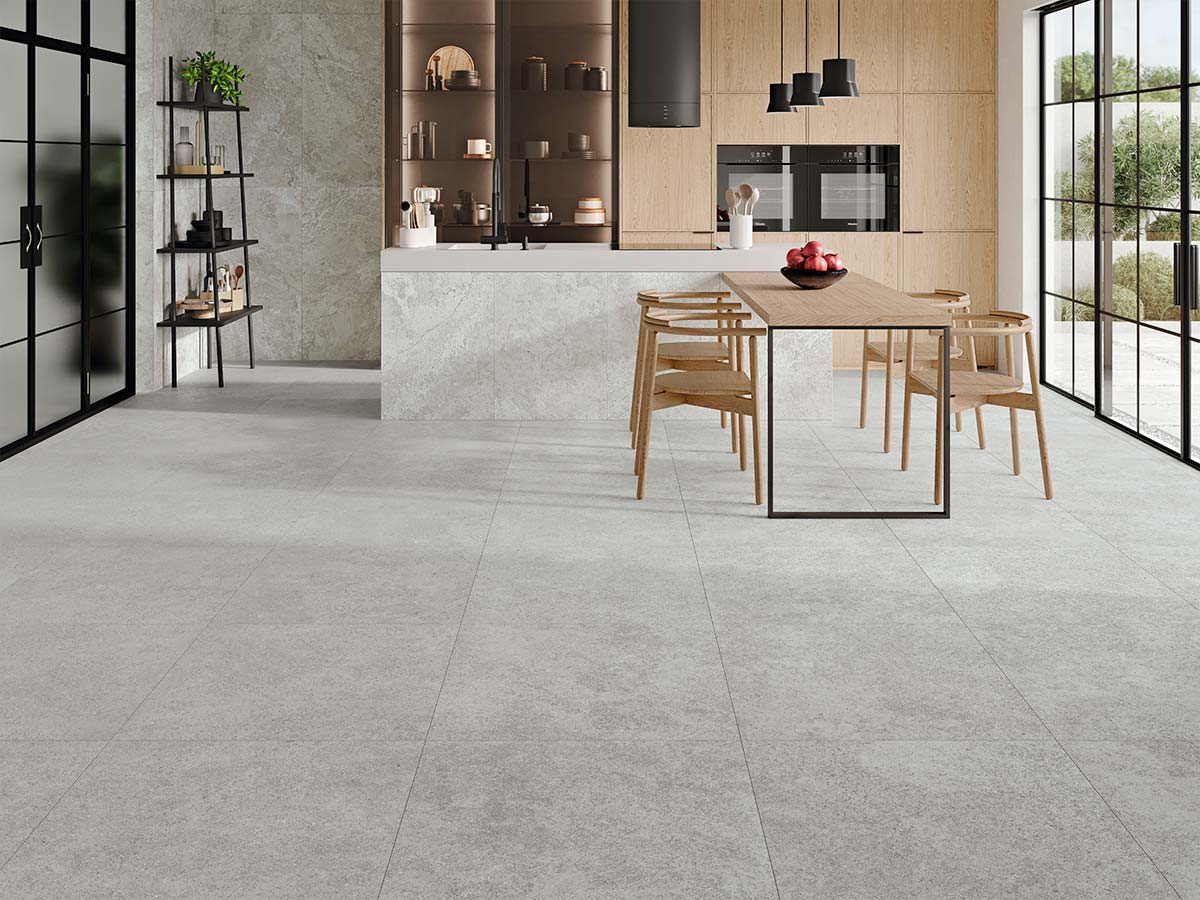 Cocina diáfana con pavimento de gres porcelánico gris claro en gran formato.