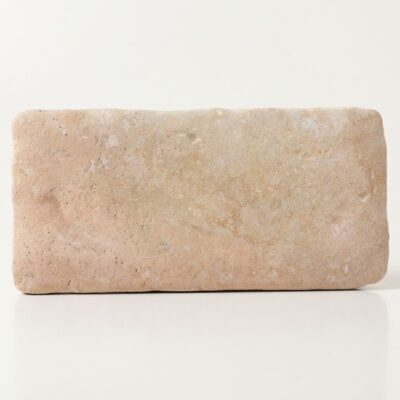 Baldosa de suelo porcelánico efecto piedra, beige claro, textura rugosa y aspecto natural.