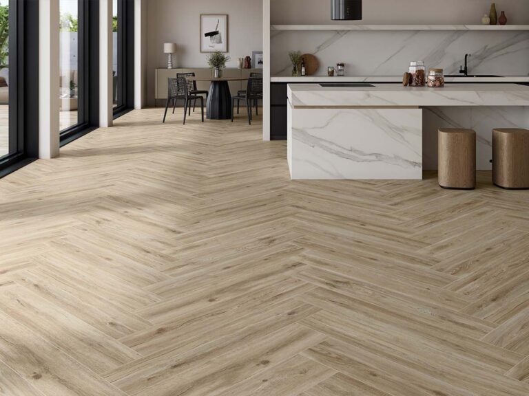 Cocina comedor con pavimento porcelánico imitación madera colocado en espiga, ideal para suelos cerámicos continuos en espacios abiertos.