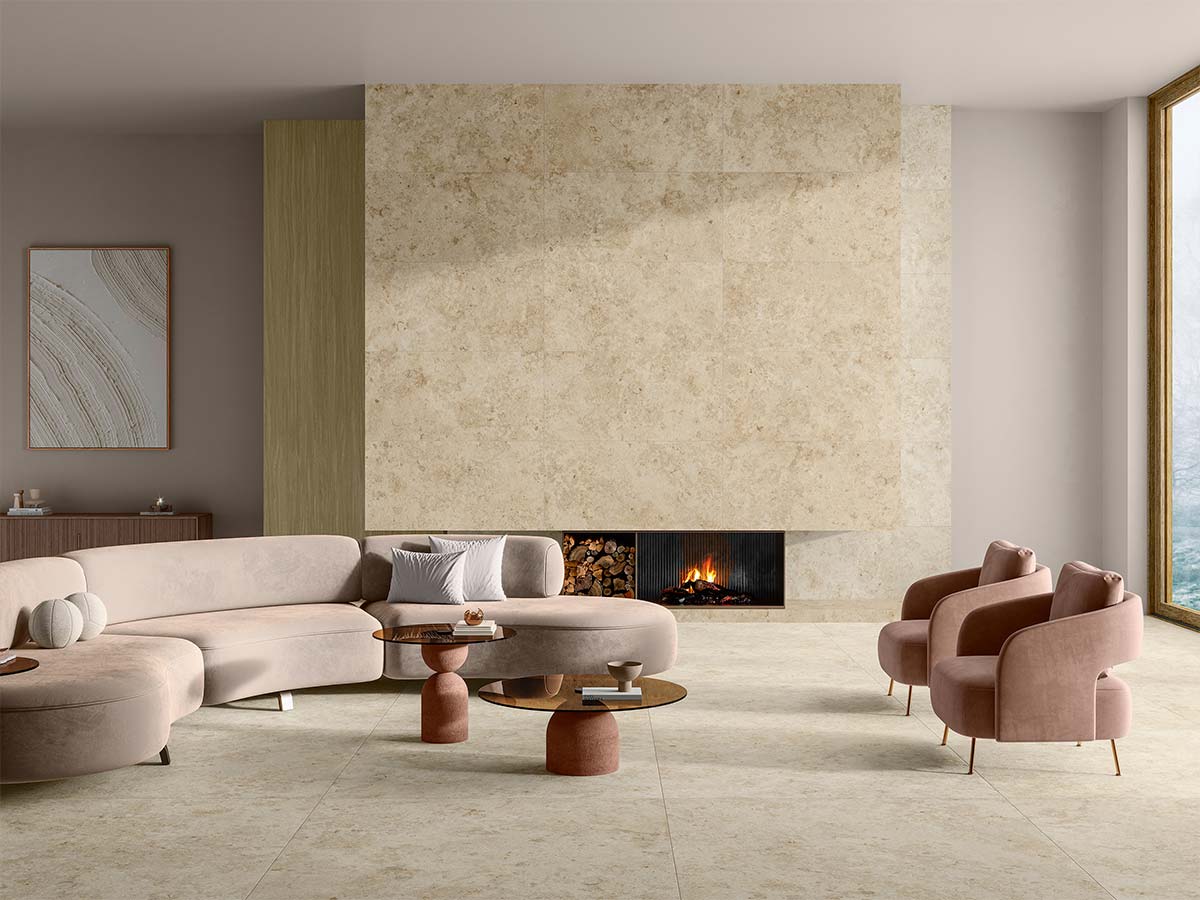 Salón amplio con pavimento de porcelánico efecto piedra travertino beige en gran formato.